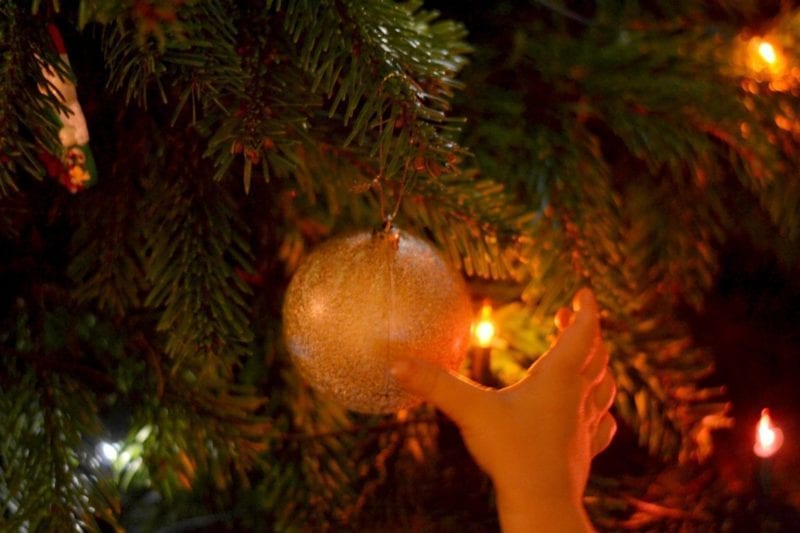 child reaching for bauble