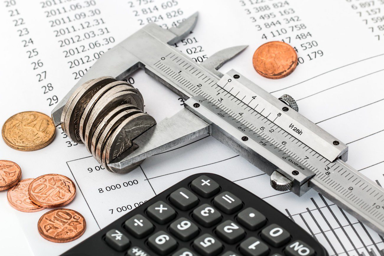 measurer with coins, calculator and document with dates on