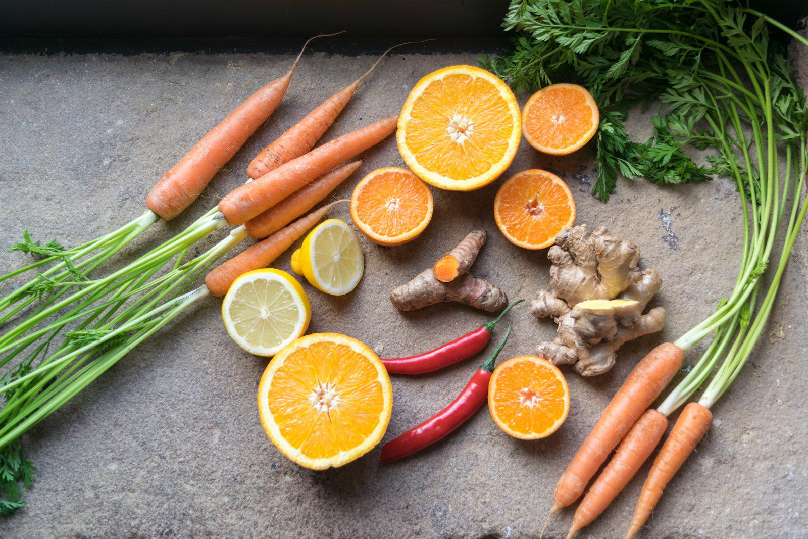 sliced orange fruit beside green and orange vegetables
