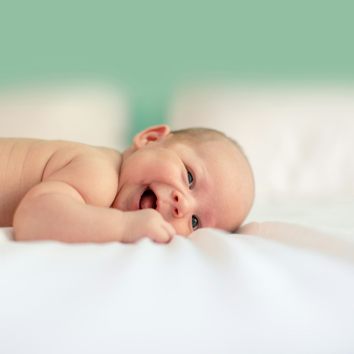 baby lying on fabric cloth with smile on face