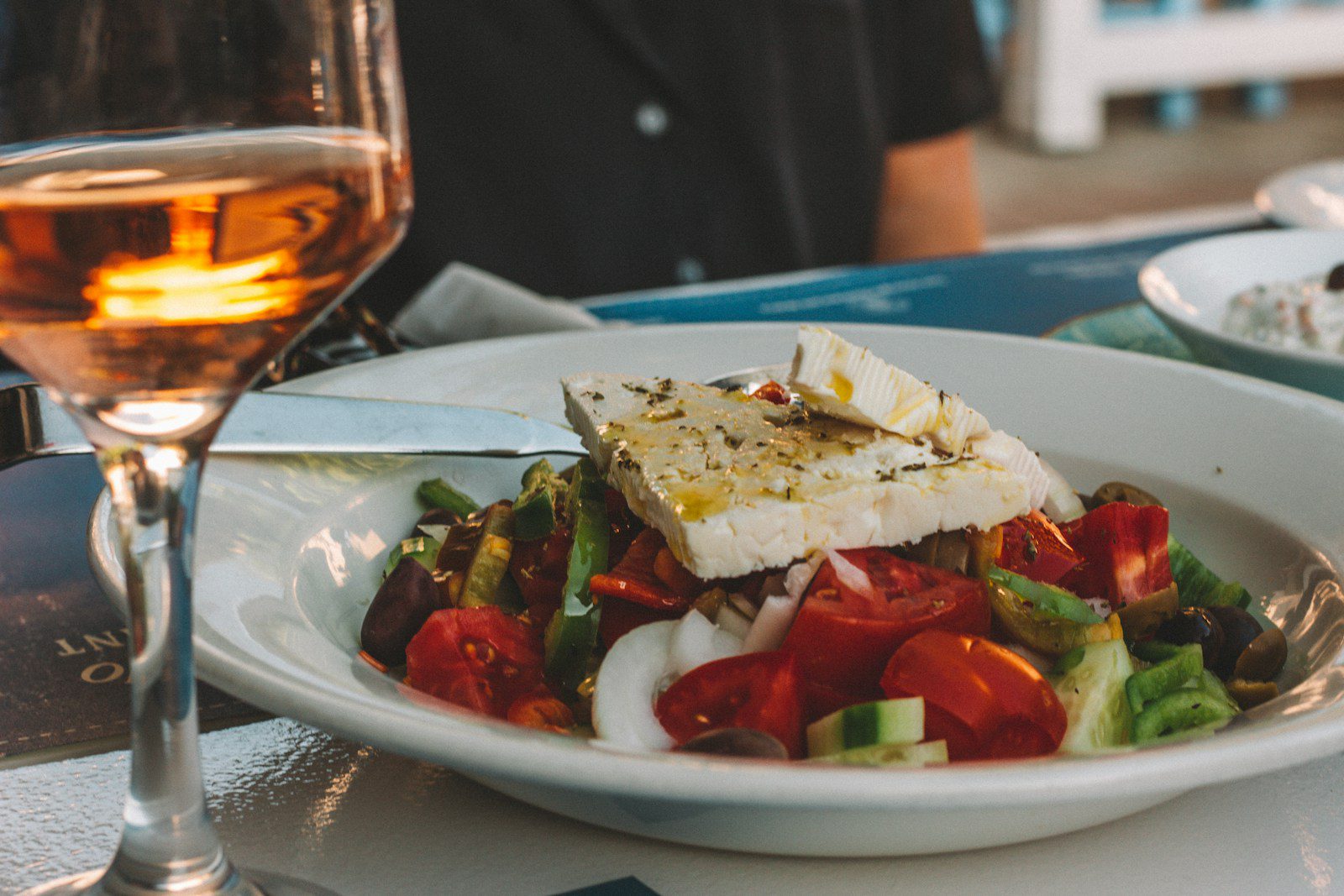 sliced tomato and cucumber on feta white ceramic plate - traditional Greek food