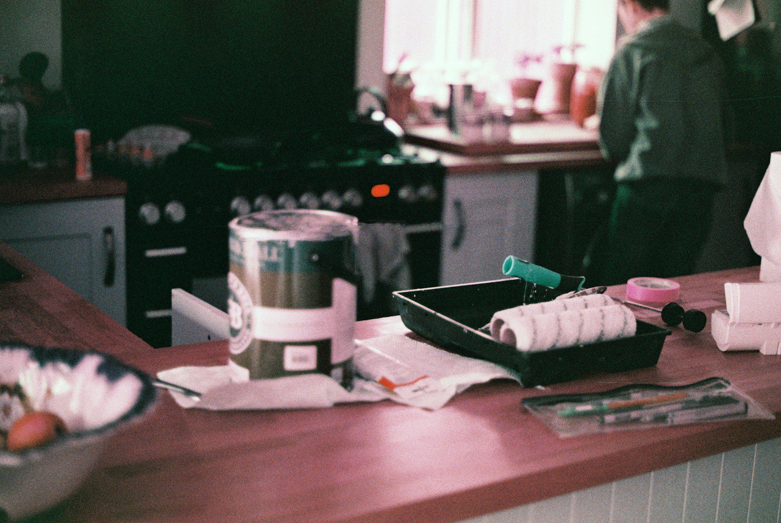pot of paint and roller and tray on kitchen island