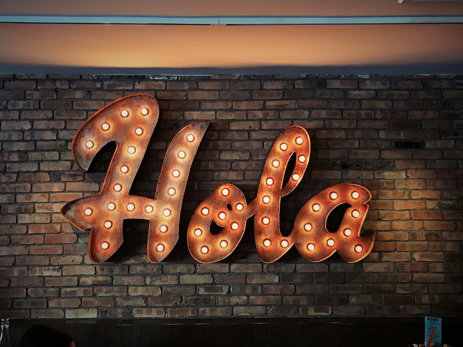 Hola LED signage on brick wall