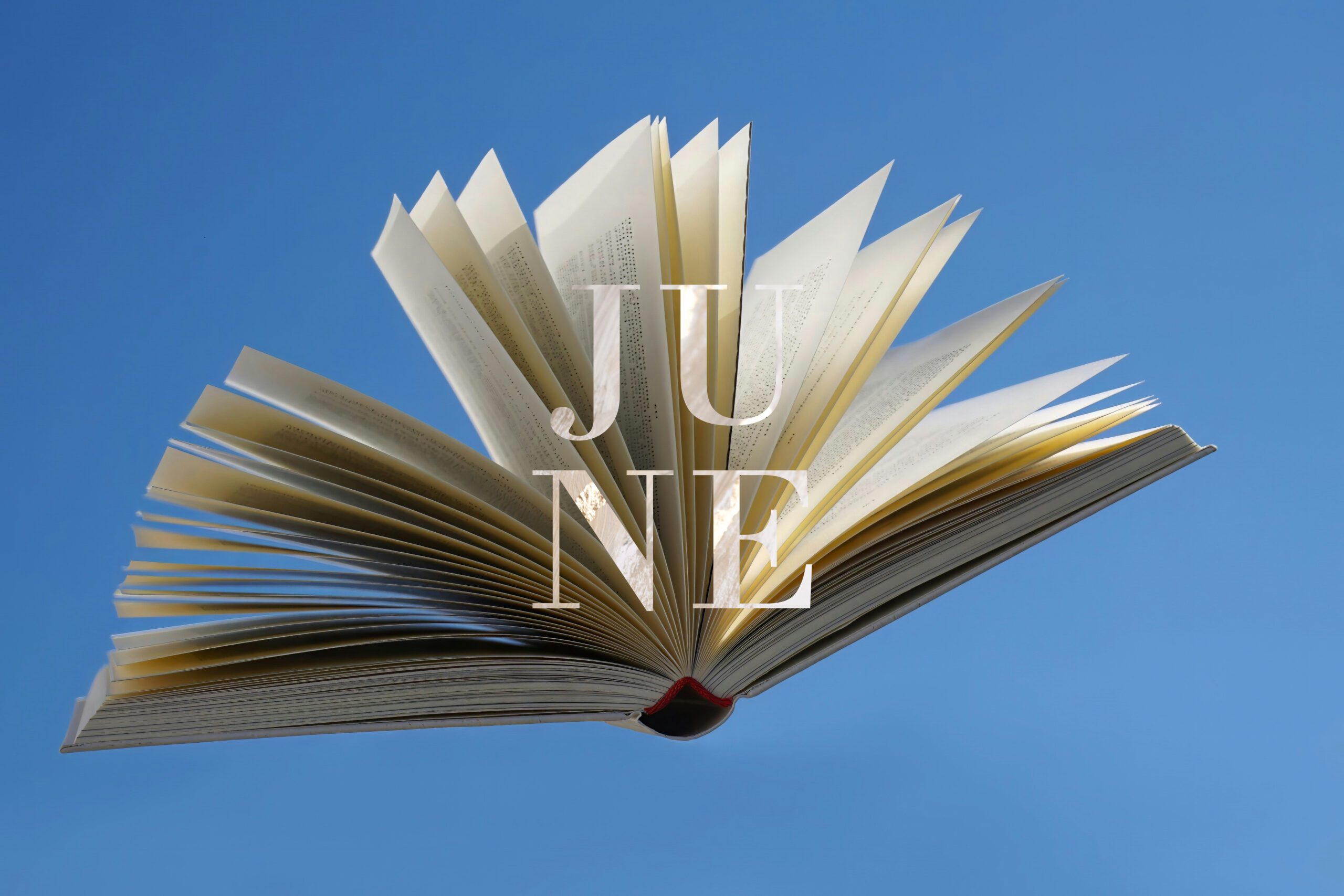 open book in the air in front of bright blue sky, with 'JUNE' lettering in front of the book
